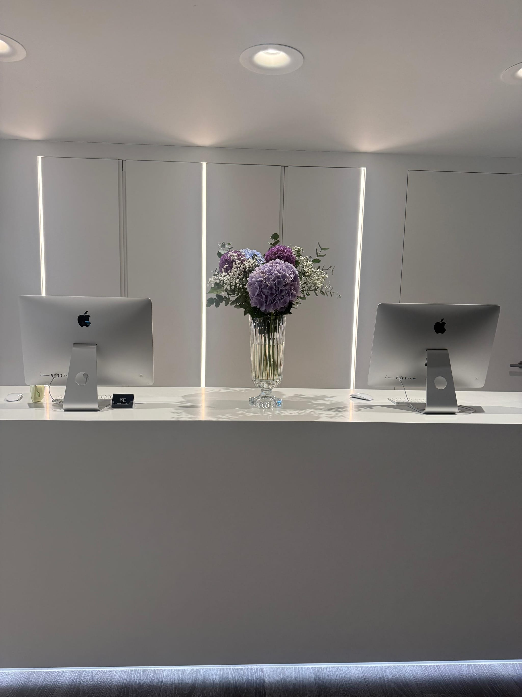 Empfangsbereich mit heller Theke und frischem Blumenschmuck